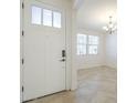 Bright entryway featuring a white front door, tile flooring, and views into the adjacent living space at 10609 E Durant Dr, Mesa, AZ 85212