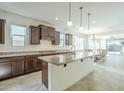 Spacious kitchen with dark wood cabinets, granite countertops, a large center island, and stainless steel appliances at 10609 E Durant Dr, Mesa, AZ 85212