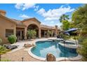 Resort-style backyard with a sparkling pool, spa, and ample patio space for entertaining at 10892 E Gold Dust Ave, Scottsdale, AZ 85259