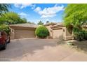 Spacious three-car garage with a wide driveway and manicured landscaping at 10892 E Gold Dust Ave, Scottsdale, AZ 85259