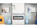 The sleek modern fireplace with decorative accents add charm to this light-filled room at 11215 N 37Th Ave, Phoenix, AZ 85029