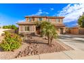 Inviting two-story home featuring lush desert landscaping and a charming desert stream rock feature in the front yard at 1179 E Regent Dr, Gilbert, AZ 85298