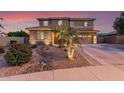 Charming two-story home with a well-manicured front yard and a cozy desert stream landscape feature at 1179 E Regent Dr, Gilbert, AZ 85298
