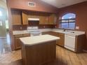 Traditional kitchen featuring wooden cabinets, center island, white appliances, and lots of counterspace at 15329 W Melissa Ln, Surprise, AZ 85374
