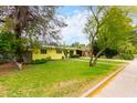 Well-manicured front lawn complements this quaint yellow home, showcasing its curb appeal at 1609 E Williams N St, Tempe, AZ 85281