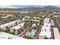 Aerial view of community with a pool, lush palm trees, and mountain backdrop at 16510 E Palisades Blvd # 42, Fountain Hills, AZ 85268