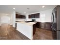 Modern kitchen featuring dark wood cabinets, white countertops, a center island with a sink, and stainless steel appliances at 16540 W Culver St, Goodyear, AZ 85338
