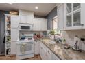 Well-lit kitchen featuring white cabinets, granite countertops, and stainless steel appliances for a sleek design at 1712 E Montebello Ave, Phoenix, AZ 85016