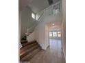 Bright foyer with staircase and view into the spacious, tiled living area at 18183 W Larkspur Dr, Goodyear, AZ 85338