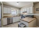 Bright kitchen featuring white cabinets, stainless steel appliances, and tile flooring at 1838 E 2Nd Pl, Mesa, AZ 85203