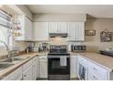 Well-lit kitchen with white cabinets, modern appliances, and neutral countertops offers functionality at 1838 E 2Nd Pl, Mesa, AZ 85203