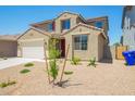 Inviting two-story home with a convenient two car garage and minimalist front yard at 18456 W Monte Lindo Ln, Surprise, AZ 85387
