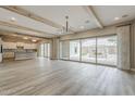 Open-concept living area featuring hardwood floors, wooden beams and a kitchen view at 18624 W Cathedral Rock Dr, Goodyear, AZ 85338