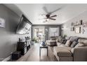 Cozy living room with gray walls, a ceiling fan, and a sliding glass door to the backyard at 1950 E Dust Devil Dr, San Tan Valley, AZ 85143