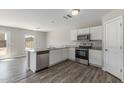 Modern kitchen featuring white cabinets, stainless steel appliances, and a peninsula with granite counters at 255 W Dewey Ave, Coolidge, AZ 85128