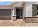 Welcoming front entry with brick accents and a stylish, covered entryway for guests at 25616 N 148Th Dr, Surprise, AZ 85387