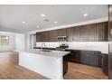 Modern kitchen featuring dark wood cabinetry, stainless steel appliances, and a large center island at 25616 N 148Th Dr, Surprise, AZ 85387