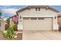 Two car garage with a driveway and a peek at some nearby landscaping at 26145 W Runion Dr, Buckeye, AZ 85396