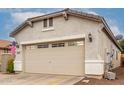 Two car garage with a partial driveway and some nearby landscaping at 26145 W Runion Dr, Buckeye, AZ 85396