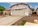 Two car garage with some nearby landscaping and a partial driveway at 26145 W Runion Dr, Buckeye, AZ 85396