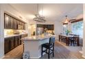 Open kitchen features granite countertops, dark cabinetry, stainless appliances, and barstool seating at the island at 288 W Los Alamos St, Gilbert, AZ 85233