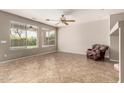 Bright living room with large windows, neutral paint, tile flooring, and a cozy chair at 3387 E Bluejay Dr, Chandler, AZ 85286