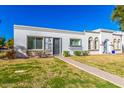 Beautiful one-story house with a well-manicured front lawn and mature trees at 5047 N 83Rd St, Scottsdale, AZ 85250
