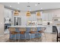 Bright kitchen features a large island with seating, stainless steel appliances, and pendant lighting at 517 S 165Th Dr, Goodyear, AZ 85338