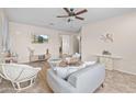 Cozy living room with neutral tones, ceiling fan, tile flooring, and comfortable wicker furniture at 517 S 165Th Dr, Goodyear, AZ 85338