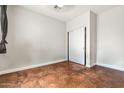 Bright, empty bedroom with neutral walls, tile flooring and a closet with sliding doors, ready for personalization at 6245 W Maya Dr, Phoenix, AZ 85083
