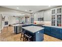 Modern kitchen featuring white and blue cabinets, stainless steel appliances, and a center island with bar seating at 6245 W Maya Dr, Phoenix, AZ 85083