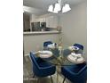 Dining area with a glass table, seating for four, and modern lighting at 6920 S 46Th Dr, Laveen, AZ 85339