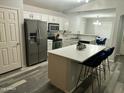 Bright kitchen featuring stainless steel appliances, island with breakfast bar, and white cabinetry at 6920 S 46Th Dr, Laveen, AZ 85339