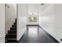 Hallway with dark wood floors, bright white walls and large window at the end of the hall at 7601 E Roosevelt St # 1007, Scottsdale, AZ 85257