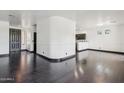 A living room features dark hardwood floors and a curved wall opening to the kitchen at 7601 E Roosevelt St # 1007, Scottsdale, AZ 85257