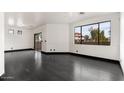 Spacious, minimalist living room with dark hardwood floors and expansive windows offering bright, natural light at 7601 E Roosevelt St # 1007, Scottsdale, AZ 85257