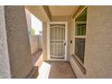 Close-up of the front door with a screen door and textured columns on either side at 809 W Kingman Dr, Casa Grande, AZ 85122