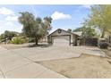 Wide shot of a home exterior featuring an attached two-car garage and a lengthy concrete driveway at 8234 W Sweetwater Ave, Peoria, AZ 85381