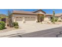 Spacious three-car garage with a wide driveway and manicured desert landscaping at 9548 E Grandview St, Mesa, AZ 85207
