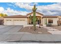 Charming single-story home with a three-car garage and desert landscaping under a partly cloudy blue sky at 9548 E Grandview St, Mesa, AZ 85207
