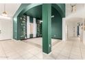 Stylish living room with green accent walls, built-in bookshelves, tile flooring, and an open layout at 9548 E Grandview St, Mesa, AZ 85207