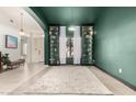 Bright living area with modern rug, green accent wall, and open view to the entryway at 9548 E Grandview St, Mesa, AZ 85207
