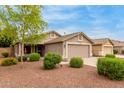 Single-story home featuring desert landscaping, a spacious driveway, and a neutral-toned exterior at 11410 W Davis Ln, Avondale, AZ 85323