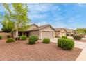 Single-story home featuring desert landscaping, a spacious driveway, and a neutral-toned exterior at 11410 W Davis Ln, Avondale, AZ 85323