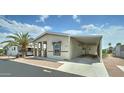 Manufactured home featuring a carport, covered porch, and desert landscaping at 11596 W Sierra Dawn Blvd # 165, Surprise, AZ 85378
