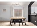 Well-lit dining room with a modern light fixture and an archway to the kitchen at 1170 E Jardin Dr, Casa Grande, AZ 85122