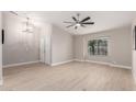 Open-concept living room with vaulted ceiling, neutral paint colors, wood-look tile floors, and a large window at 1333 E Bermuda Bay Ct, Gilbert, AZ 85234