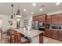 Modern kitchen with granite countertops, stainless steel appliances, and a center island with bar seating at 13720 W Amberwing St, Peoria, AZ 85383