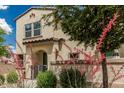 Beautiful two-story home enhanced by vibrant desert landscaping, a gate, and a tidy walkway at 14870 W Encanto Blvd # 1061, Goodyear, AZ 85395