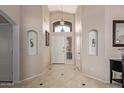 Bright foyer features tiled floors, high ceilings, decorative niches, and a beautiful chandelier at 16280 W Durango St, Goodyear, AZ 85338